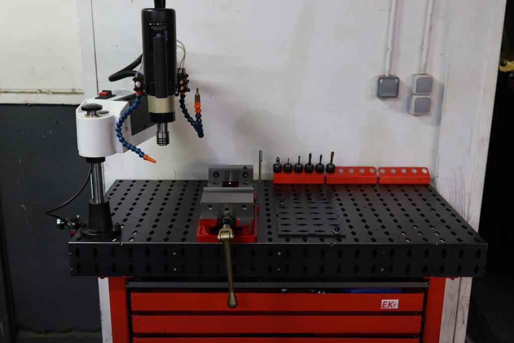 Un bras de taraudage installé sur une table de soudure EKI120